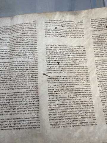 Note the holes in the klaf/parchment which have now been carefully repaired